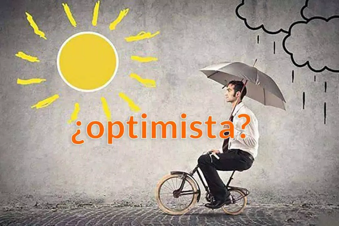 Un hombre anda en una pequeña bicicleta sosteniendo un paraguas mientras la lluvia cae de un lado y el sol brilla del otro, encarnando tanto oportunidades como optimismo. El texto "¿optimista?" se visualiza.